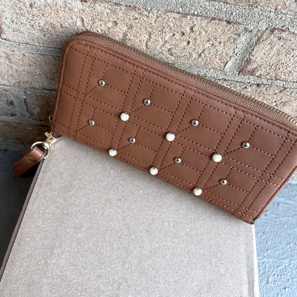 Never used. Tan wallet with imitation gold/pearl buttons.
